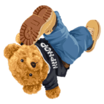 Urso de pelúcia estilizado com roupas de hip-hop, usando calças jeans e um tênis amarelo, em uma pose divertida.