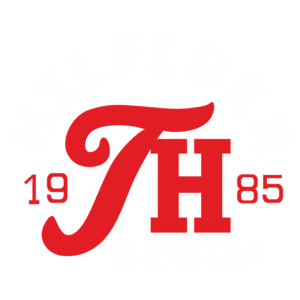 Logotipo da marca Hilfiger Denim, apresentando as letras "H" e "TH" em vermelho, com o ano "1985" em destaque. O design combina elementos modernos e vintage, representando o estilo icônico da marca.